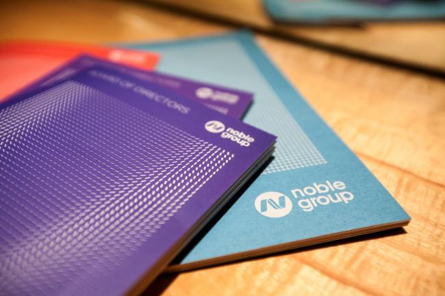 © Bloomberg. Noble Group Ltd. booklets sit on a table before a news conference during an investor day in Singapore, on Monday, Aug. 17, 2015.  Photographer: Nicky Loh/Bloomberg