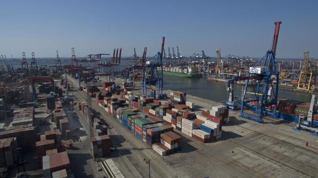 © Bloomberg. Container ships are moored next to gantry cranes and shipping containers in this aerial photograph taken above Tanjung Priok Port in Jakarta, Indonesia on Monday, Aug. 3, 2015. Gross domestic product is expected to expand 4.64 percent versus a year earlier from April through June in data due on Aug. 5, according to the median of a Bloomberg News survey of economists. Photographer: Dimas Ardian