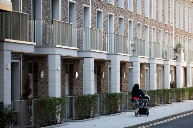 © Bloomberg. A pedestrian passes a row of new houses in the Royal Wharf development in London, U.K., on Tuesday, Oct. 16, 2018. The end of London's long property boom is starting to ripple across the U.K.’s homebuilders. Photographer: Chris Ratcliffe/Bloomberg