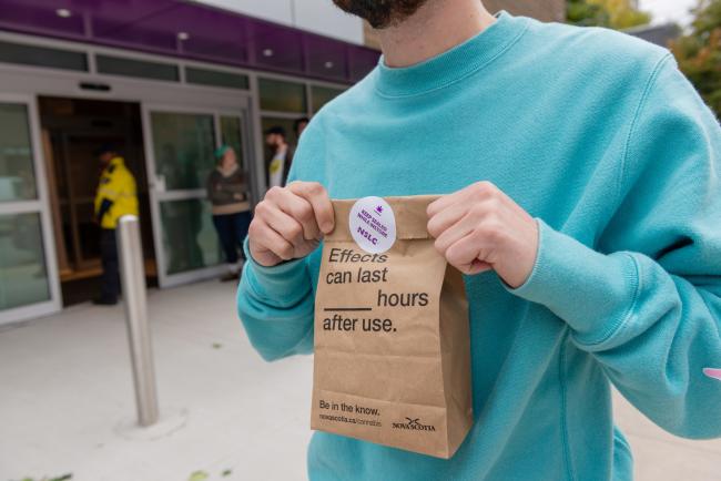© Bloomberg. A customer holds a sealed bag containing cannabis products outside of a store in Halifax on Oct. 17. Photographer: Dean Casavechia/Bloomberg