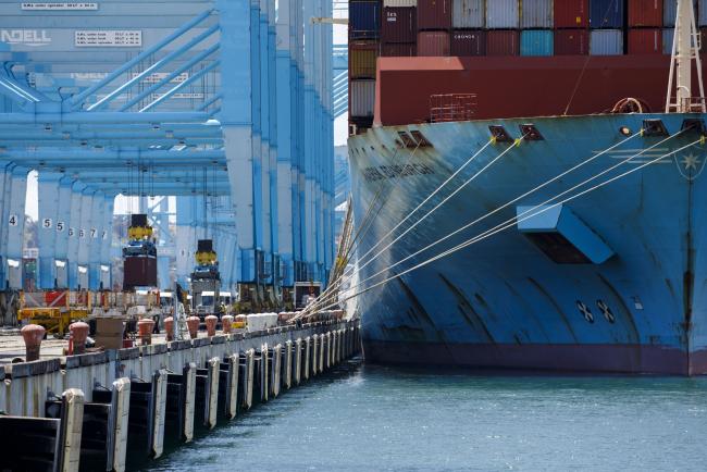 © Bloomberg. Shipping containers are unloaded from the Maersk Edinburgh cargo ship at the APM shipping terminal in the Port of Los Angeles in Los Angeles, California, U.S., on Tuesday, May 7, 2019. The terminal is planning to replace diesel trucks and human workers. It has already ordered an electric, automated carrier from Finnish manufacturer Kalmar, part of the Cargotec Corp., that can fulfill the functions of three kinds of manned diesel vehicles: a crane, top-loader and truck. 