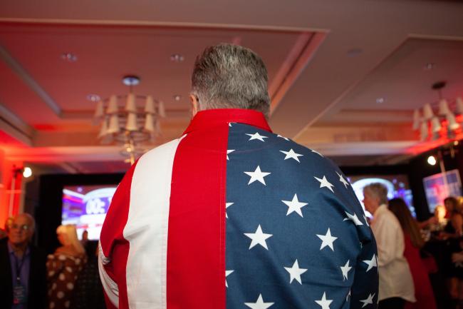 © Bloomberg. An attendee wears an American flag themed shirt during an election night rally for Rick Scott, governor of Florida and Republican U.S. Senate Candidate, in Naples, Florida, U.S., on Tuesday, Nov. 6, 2018. Photographer: Jayme Gershen/Bloomberg