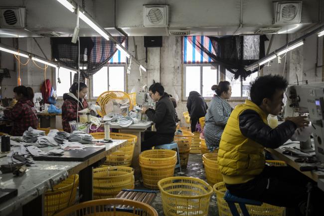 © Bloomberg. Employees sew shoe components in a factory in Wenzhou, China, on Monday, Jan. 14, 2019. The Chinese government's effort to pivot from being the world's supplier of goods to a nation that's increasingly competing for technological dominance is shaking up the global order. Photographer: Qilai Shen/Bloomberg