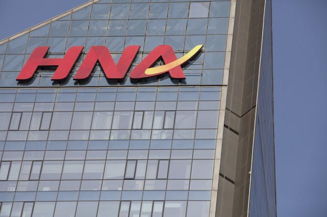 © Bloomberg. Signage for HNA Group Co. is displayed atop the company's building in Beijing, China, on Thursday, Feb. 1, 2018. Companies linked toHNAhave secured 7.8 billion yuan ($1.2 billion) in long-term loans from Chinese banks to finance an expansion project in Meilan Airport inHNA's home province of Hainan.