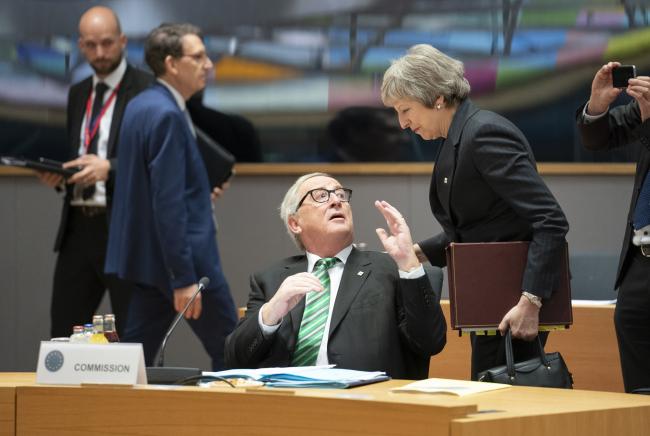 © Bloomberg. Jean-Claude Juncker, president of the European Commission, center, speaks with Theresa May, U.K. prime minister, during a roundtable discussion at a European Union (EU) leaders summit in Brussels, Belgium, on Thursday, Dec. 13, 2018. May staggers on to Brussels on Thursday to plead for a lifeline after her much-loathed Brexit plans provoked a revolt from her Conservative Party. 