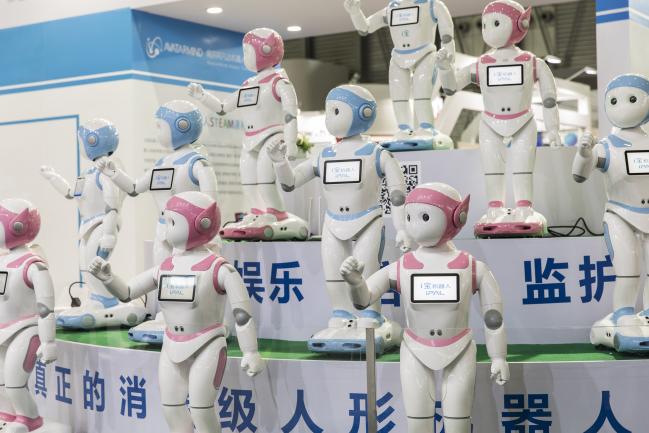 © Bloomberg. IPal teaching robots stand on display at the AvatarMind booth at the CES Asia 2018 show in Shanghai, China, on Wednesday, June 13, 2018. The show runs through June 15. 