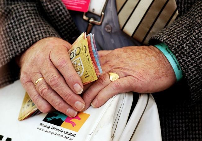 © Bloomberg. MELBOURNE, AUSTRALIA - NOVEMBER 06: (EDITORIAL USE ONLY) A bookie holds money at The Melbourne Cup Carnival meeting at Flemington Racecourse November 6, 2007 in Melbourne, Australia. (Photo by Quinn Rooney/Getty Images)
