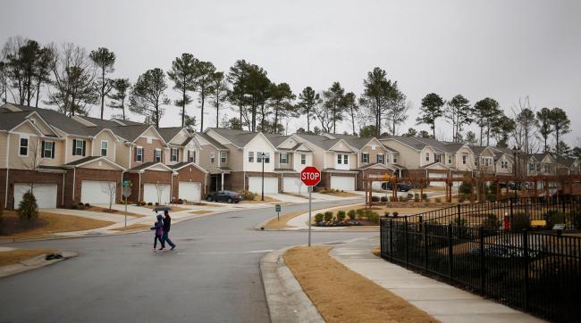 © Bloomberg. Pedestrians pass in front of residential buildings in the KB Home Glencroft neighborhood of Cary, North Carolina, U.S., on Friday, Jan. 6, 2017. Photographer: Luke Sharrett/Bloomberg