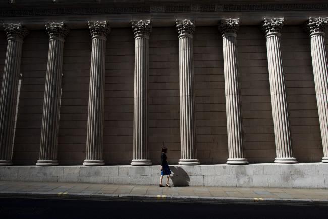 © Bloomberg. A pedestrian walks past the Bank of England in the City of London, U.K., on Monday July 31, 2017. Consumer credit growth slowed in June after the Bank of England officials took action to limit some areas of risk of borrowing.