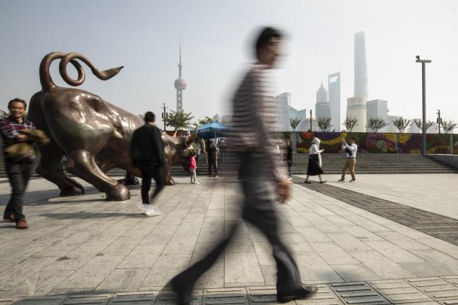 © Bloomberg. People take photographs with the Bund Bull statue in Shanghai, China, on Wednesday, Oct. 24, 2018. 