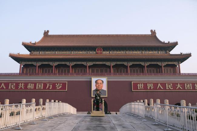 © Bloomberg. A member of the Chinese People's Armed Police stands guard in front of a portrait of former Chinese leader Mao Zedong at Tiananmen Square in Beijing, China, on Monday, March 4, 2019. National People's Congress spokesman Zhang Yesui said at a briefing on Monday that China would need to increase its military spending to protect itself and that it doesn't pose a threat to other countries. Photographer: Giulia Marchi/Bloomberg