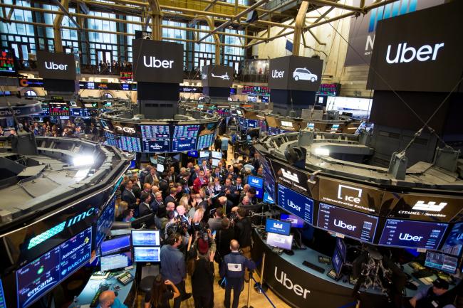 © Bloomberg. Traders work during Uber Inc.'s initial public offering on the floor of the New York Stock Exchange on May 10, 2019. 