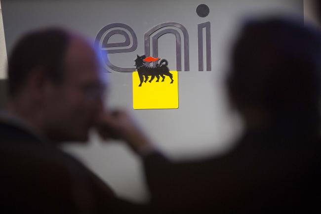 © Bloomberg. A Eni SpA logo is seen during a news conference following the company's 2014-2017 strategy presentation in London, U.K., on Thursday, Feb. 13, 2014. Eni SpA, Italy's biggest oil company, said profit slumped 14 percent in the fourth quarter due to production halts in Libya and Nigeria and shrinking refining margins.