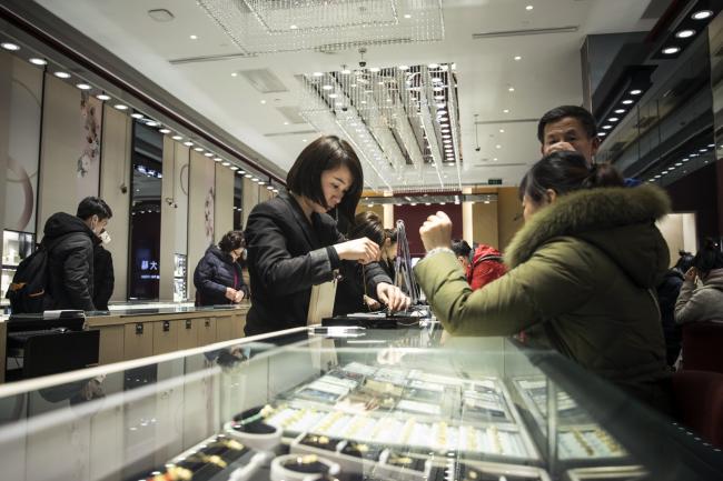 © Bloomberg. Customers shop for jewelry at a Chow Tai Fook store.