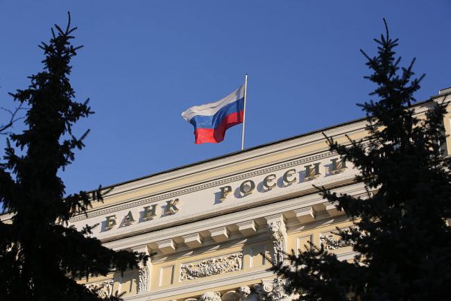 © Bloomberg. A Russian national flag flies above the headquarters of Bank Rossii, Russia's central bank, in Moscow, Russia. Photographer: Bloomberg/Bloomberg