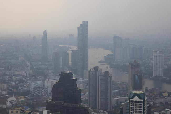 © Bloomberg. Buildings stand shrouded in smog along the Chao Phraya river in Bangkok, on Jan. 14. Photographer: Brent Lewin/Bloomberg