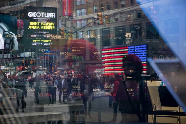 © Bloomberg. Monitors display stock market information as pedestrians are reflected in a window at the Nasdaq MarketSite in the Times Square area of New York, U.S., on Friday, April 26, 2019. U.S. stocks edged higher on better-than-forecast earnings while Treasury yields fell after data signaled tepid inflation in the first quarter. Photographer: Michael Nagle/Bloomberg