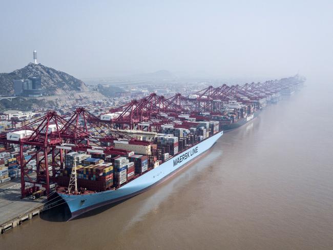 © Bloomberg. An A.P. Moller-Maersk A/S container ship and a Hapag-Lloyd AG container ship are docked as shipping containers stand in a terminal at the Yangshan Deep Water Port in this aerial photograph taken in Shanghai. 