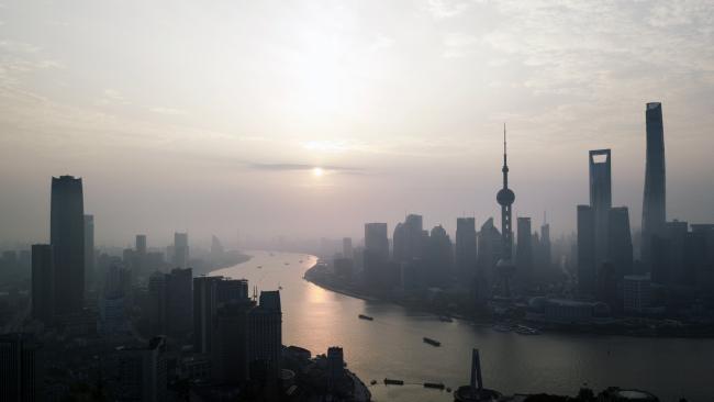 © Bloomberg. The Shanghai Tower, right, Shanghai World Financial Center, second right, and Oriental Pearl Tower, third right, stand among other buildings in the Lujiazui Financial District along the Pudong riverside in this aerial photograph taken above Shanghai, China. Photographer: Qilai Shen/Bloomberg