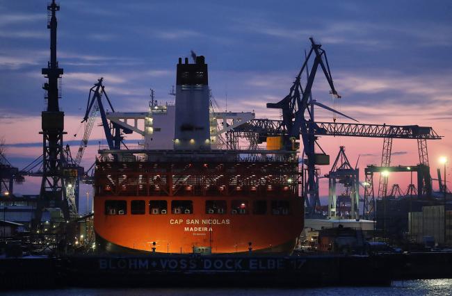 © Bloomberg. Container ship Cap San Nicolas, operated by Hamburg Sued, sits moored at the Blohm + Voss maintenance shipyard during sunset at the Port of Hamburg in Hamburg, Germany, on Tuesday, Feb. 27, 2018. The euro-area economy has been put on notice that there’s no guarantee the good times last forever. Photographer: Krisztian Bocsi/Bloomberg