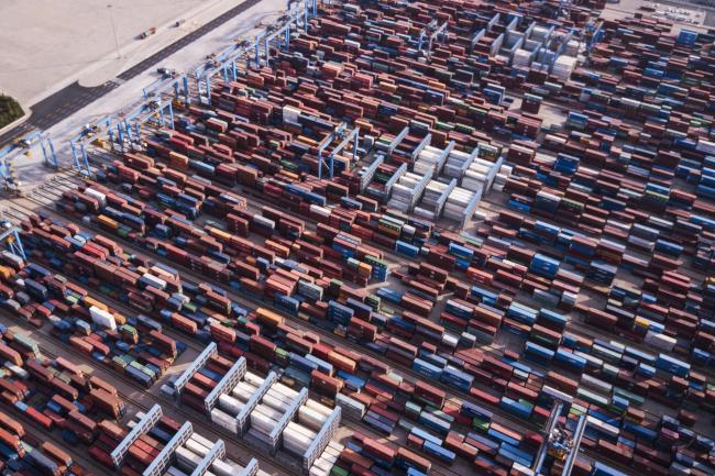 © Bloomberg. Shipping containers stand at the Qingdao Qianwan Container Terminal in this aerial photograph taken in Qingdao, China, on Monday, May 7, 2018. China's overseas shipments exceeded estimates while imports surged, as the global economy continued to support demand. Photographer: Qilai Shen/Bloomberg