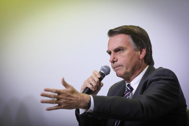 © Bloomberg. Jair Bolsonaro, presidential candidate for the Social Liberal Party (PSL), speaks during an interview at a 2018 pre-candidates event hosted by the Correio Braziliense newspaper in Brasilia, Brazil, on Wednesday, June 6, 2018. Brazil's presidential race has grown increasingly polarized between far-right and leftist candidates, according to an opinion poll published by Poder360. Photographer: Andre Coelho/Bloomberg
        