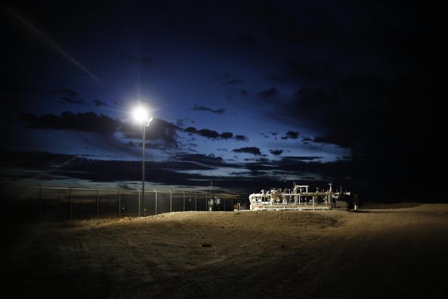 © Bloomberg. Valves stand on the grounds of an oil tank farm at dusk in Midland, Texas, U.S. Photographer: Luke Sharrett/Bloomberg