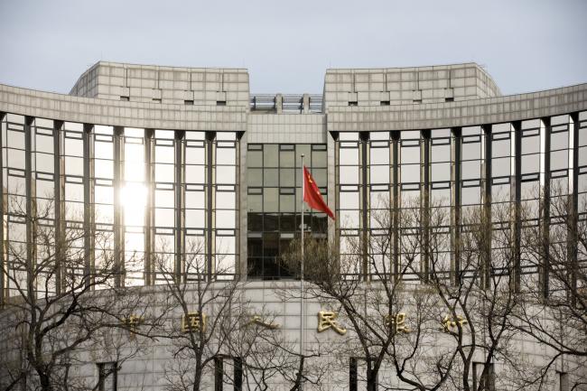 © Bloomberg. A Chinese flag flies in front of the People's Bank of China headquarters in Beijing, China, on Monday, Jan. 7, 2019. The central bank on Friday announced another cut to the amount of cash lenders must hold as reserves in a move to release a net 800 billion yuan ($117 billion) of liquidity and offset a funding squeeze ahead of the Chinese New Year. 