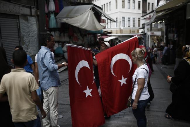 © Bloomberg. A street vendor sells Turkish flags to tourists in the Sultanahmet district of Istanbul, Turkey, on Thursday, Aug. 3, 2017. Turkey’s central bank raised its inflation forecast for this year on higher food prices, and reiterated its policy not to loosen monetary conditions until the outlook improves. Photographer: Kostas Tsironis/Bloomberg