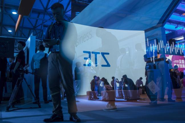 © Bloomberg. The ZTE Corp. logo projected on a screen is reflected on a pane of glass at the Ericsson AB booth at the Mobile World Congress Shanghai in Shanghai, China, on Thursday, June 28, 2018. The exhibition runs through June 29. Photographer: Qilai Shen/Bloomberg