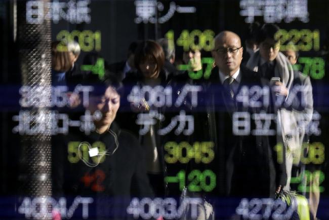 © Bloomberg. Pedestrians are reflected in an electronic stock board outside a securities firm in Tokyo, Japan, on Thursday, Dec. 20, 2018. Japanese stocks entered a bear market as the last policy statements of the year from the Federal Reserve and Bank of Japan added to mounting investor concerns. Photographer: Kiyoshi Ota/Bloomberg