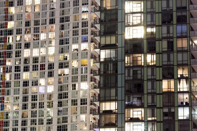 © Bloomberg. Condominium windows are seen illuminated at night in Toronto, Ontario, Canada, on Friday, May 26, 2017. Canadian mortgage growth is slowing as the country's policy makers step up efforts to cool overheated housing markets in Vancouver and Toronto. With four of Canada's biggest banks reporting second-quarter results, the trend shows that growth in home loan portfolios is easing and in some cases shrinking.