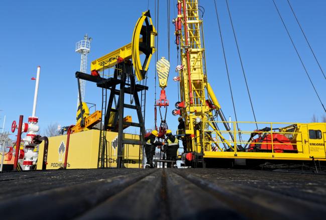 © Bloomberg. Workers perform a well-workover operation at a multiple well platform, operated by Rosneft PJSC, in the Samotlor oilfield near Nizhnevartovsk, Russia, on Monday, March 20, 2017. Russia's largest oil field, so far past its prime that it now pumps almost 20 times more water than crude, could be on the verge of gushing profits again for Rosneft PJSC. 