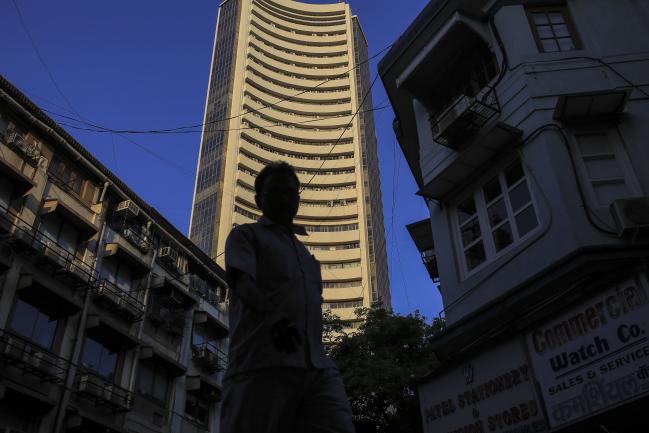 © Bloomberg. A pedestrian is silhouetted as the Bombay Stock Exchange (BSE) building, center, stands the background in Mumbai, India, on Tuesday, Dec. 11, 2018. India’s new central bank governor has a list of challenges to face as he takes office: from fixing a banking crisis to convincing investors of the institution’s autonomy. Photographer: Dhiraj Singh/Bloomberg