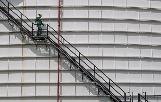 © Bloomberg. An employee descends the steps outside a 40,000 tonnes crude oil storage tank at the Duna oil refinery, operated by MOL Hungarian Oil & Gas Plc, in Szazhalombatta, Hungary, on Monday, April 10, 2017. MOL Group posted almost $1 Billion profit in 2016.