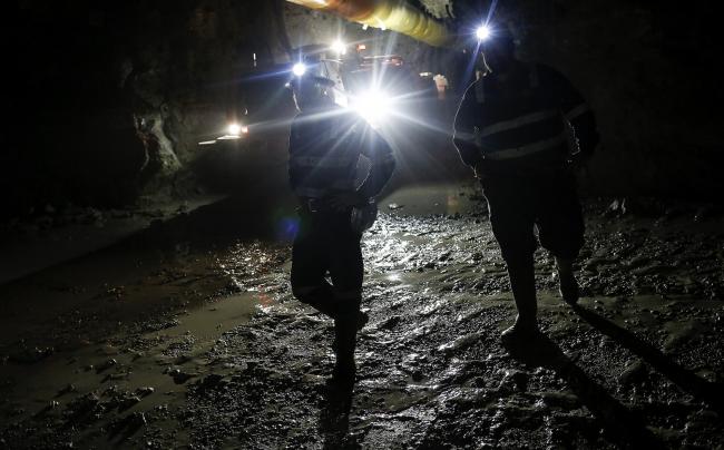 © Bloomberg. Mine workers inspect a rock wall by flashlight while identifying drilling locations in the underground tunnels at the Kibali gold mine, operated by Randgold Resources Ltd., in Kibali, Democratic Republic of Congo, on Friday, Oct. 17, 2014. Randgold and AngloGold Ashanti Ltd. gained control of the Kibali mine by acquiring Moto Goldmines Ltd. in 2009 and is forecast to produce about 600,000 ounces of gold a year.