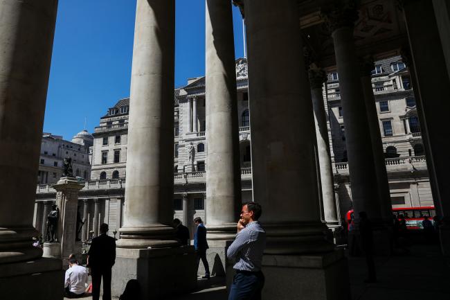 © Bloomberg. Pedestrians stand near the Bank of England (BOE) in the City of London, U.K., on Wednesday, June 27, 2018. The BOE stepped up pressure on the European Union to remove the threat that Brexit poses to trillions of pounds of derivative contracts. 