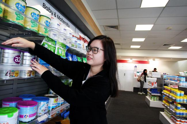 © Bloomberg. A store employee stocks shelves at the Australia Post store. Photographer: Lisa Maree Williams/Bloomberg