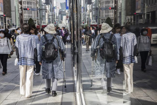 © Bloomberg. Pedestrians are reflected in windows at the Ginza district of Tokyo, Japan, on Friday, May 25, 2018.  Photographer: Shiho Fukada/Bloomberg