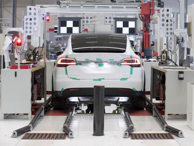 © Bloomberg. A Tesla Model X sports utility vehicle (SUV) undergoes wheel alignment checks during assembly for the European market at the Tesla Motors Inc. factory in Tilburg, Netherlands. 