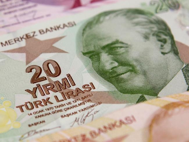 © Bloomberg. Turkish 10 and 20 lira banknotes sit on the counter of a currency exchange bureau in Istanbul, Turkey. Photographer: Kerem Uzel