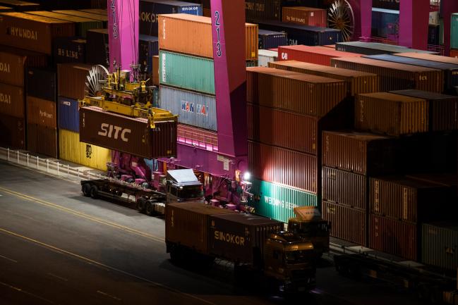 © Bloomberg. A gantry crane unloads a SITC International Holdings Co. container from a truck at the Sun Kwang Newport Container Terminal (SNCT) at night in Incheon New Port in Incheon, South Korea, on Friday, March 2, 2018. President Donald Trump said the U.S. would slap tariffs on steel and aluminum imports to protect national security, prompting threats of retaliation from China to Europe. 