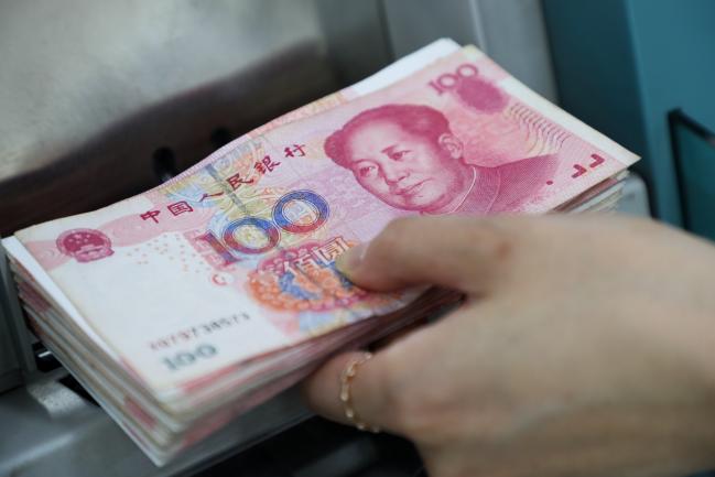 © Bloomberg. An employee places genuine Chinese one-hundred yuan banknotes into a counting machine at the Counterfeit Notes Response Center of KEB Hana Bank in Seoul, South Korea, on Friday, July 13, 2017. Yuan is set to slide for fifth week, longest losing streak since July 2016, as escalating U.S.-China trade tensions weigh on sentiment. Photographer: SeongJoon Cho/Bloomberg