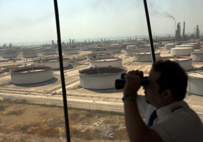 © Bloomberg. An employee uses binoculars to look out towards the Arabian Sea in the Port Control Center at Saudi Aramco's Ras Tanura oil refinery and terminal in Ras Tanura, Saudi Arabia, on Monday, Oct. 1, 2018.  Photographer: Simon Dawson/Bloomberg