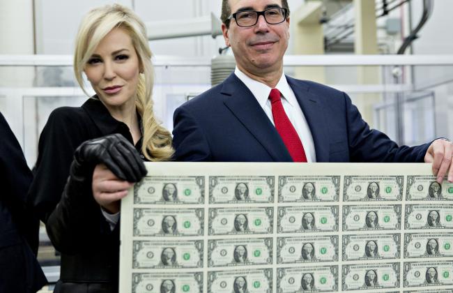 © Bloomberg. Steven Mnuchin, U.S. Treasury secretary, right, and his wife Louise Linton hold a 2017 50 subject uncut sheet of $1 dollar notes bearing Mnuchin's name for a photograph at the U.S. Bureau of Engraving and Printing in Washington, D.C., U.S., on Wednesday, Nov. 15, 2017. A change in the Senate tax-overhaul plan that would expand a temporary income-tax break for partnerships, limited liability companies and other so-called 