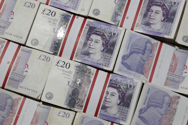 © Bloomberg. Bundles of 20 pound sterling banknotes are arranged for a photograph inside a Travelex store, operated by Travelex Holdings Ltd., in London, U.K. Photographer: Matthew Lloyd/Bloomberg