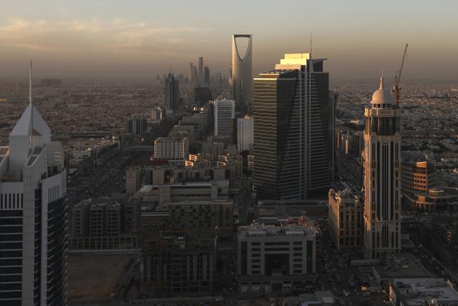 © Bloomberg. The Kingdom Tower, center rear, stands as automobile traffic moves along the King Fahd highway, left and Olaya Street, right, in Riyadh. Photographer: Simon Dawson/Bloomberg