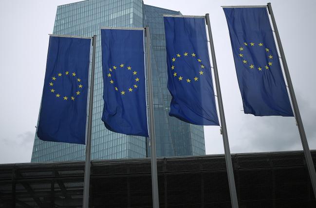 © Bloomberg. The stars of the European Union (EU) sit on banners flying outside the European Central Bank (ECB) headquarters in Frankfurt, Germany, on Thursday, July 20, 2018. When theECBpresident speaks to reporters on Thursday after the Governing Council sets policy, hell have to balance optimism over the revival against a desire to move as slowly as possible when removing monetary stimulus.