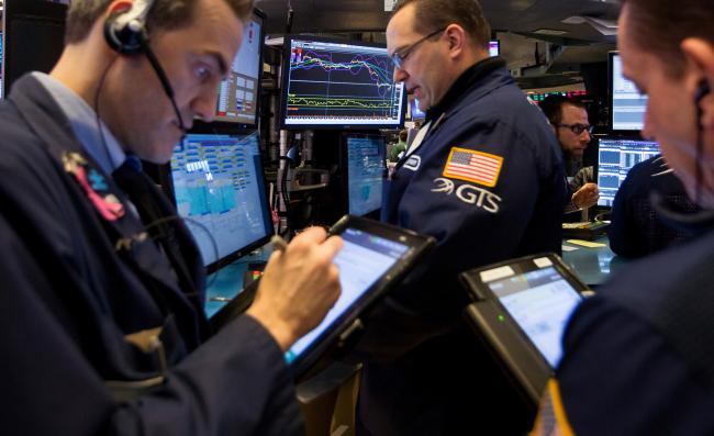 © Bloomberg. Traders work on the floor of the New York Stock Exchange (NYSE) in New York, U.S., on Friday, Feb. 9, 2018. The convulsions rocking U.S. equity markets continued Friday, with major indexes headed for the worst week in almost seven years after falling back from early gains. Treasury declines eased as investors sought havens from gold to the yen.