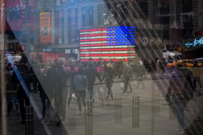 © Bloomberg. Pedestrians are reflected in a window of the Nasdaq MarketSite in the Times Square neighborhood of New York, U.S., on Monday, April 8, 2019. U.S. stocks pared losses as investors awaited signs of progress in the trade war with China ahead of the latest corporate earnings season. Photographer: Michael Nagle/Bloomberg